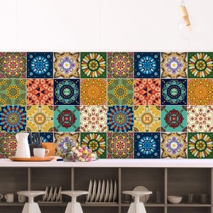 May include: A wall covered in square tiles featuring a repeating pattern of colorful mandalas in shades of blue, green, yellow, red, and orange. The tiles are arranged in a grid, creating a vibrant, multi-colored surface behind a kitchen counter.