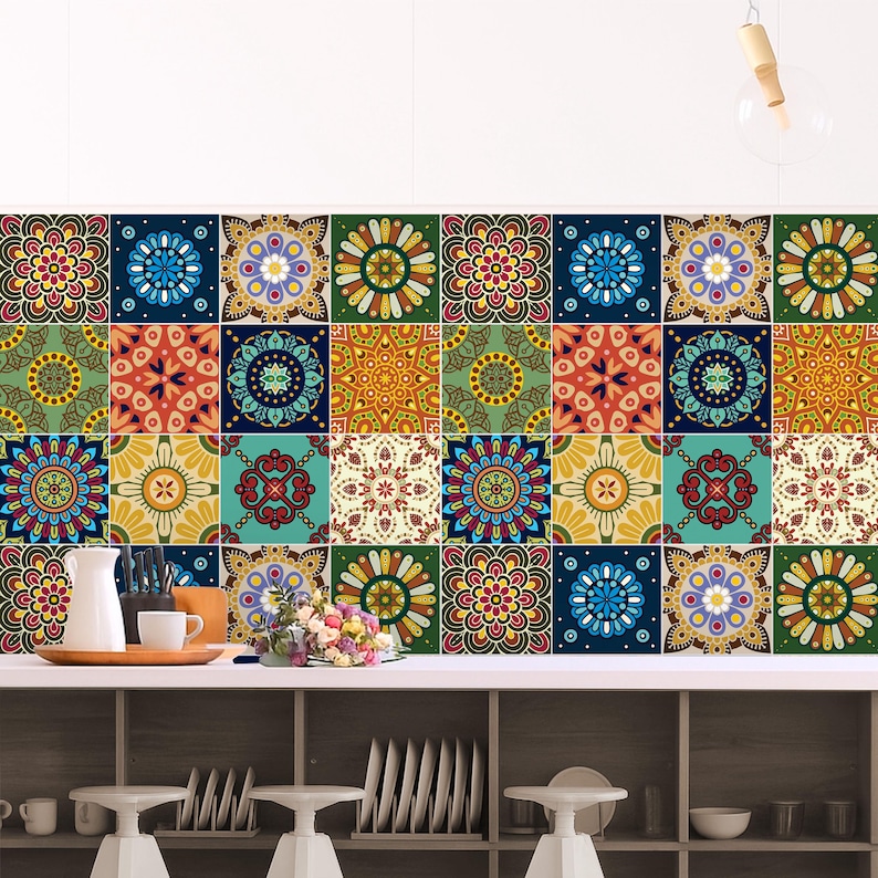 May include: A wall covered in square tiles featuring a repeating pattern of colorful mandalas in shades of blue, green, yellow, red, and orange. The tiles are arranged in a grid, creating a vibrant, multi-colored surface behind a kitchen counter.