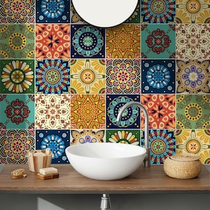Puede incluir: Un lavabo de cer&aacute;mica blanca se asienta sobre una encimera de madera oscura frente a una pared cubierta de azulejos cuadrados con varios patrones de mandala coloridos en tonos azul, rojo, amarillo y verde, con un grifo plateado y un espejo redondo.