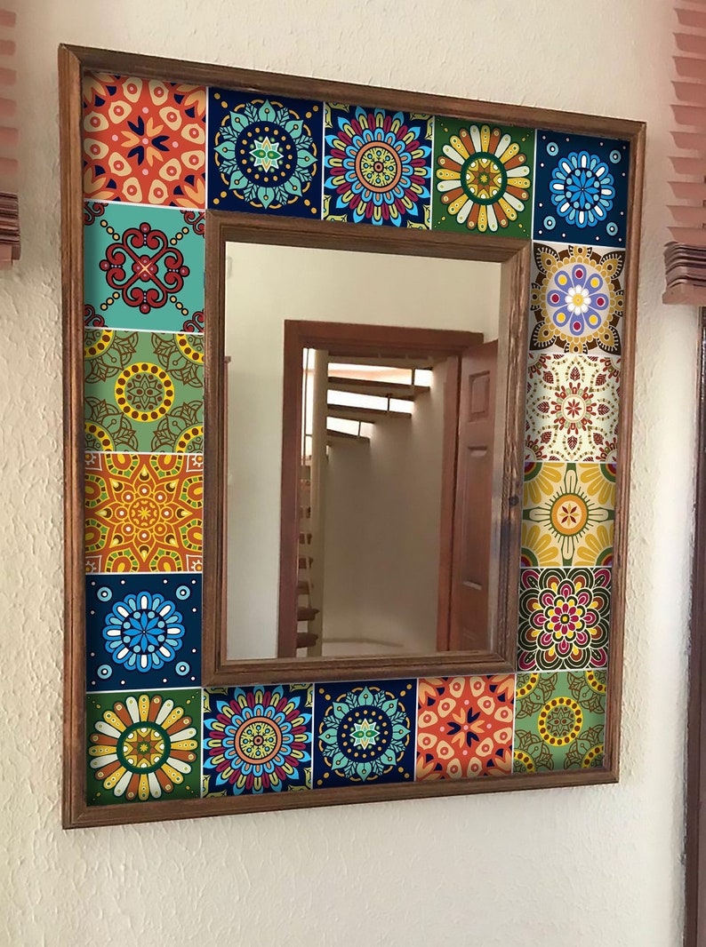 May include: A square wall mirror featuring a wooden frame decorated with a border of colorful, patterned square tiles. The tiles display various intricate geometric and floral designs in shades of blue, orange, yellow, green, and white.