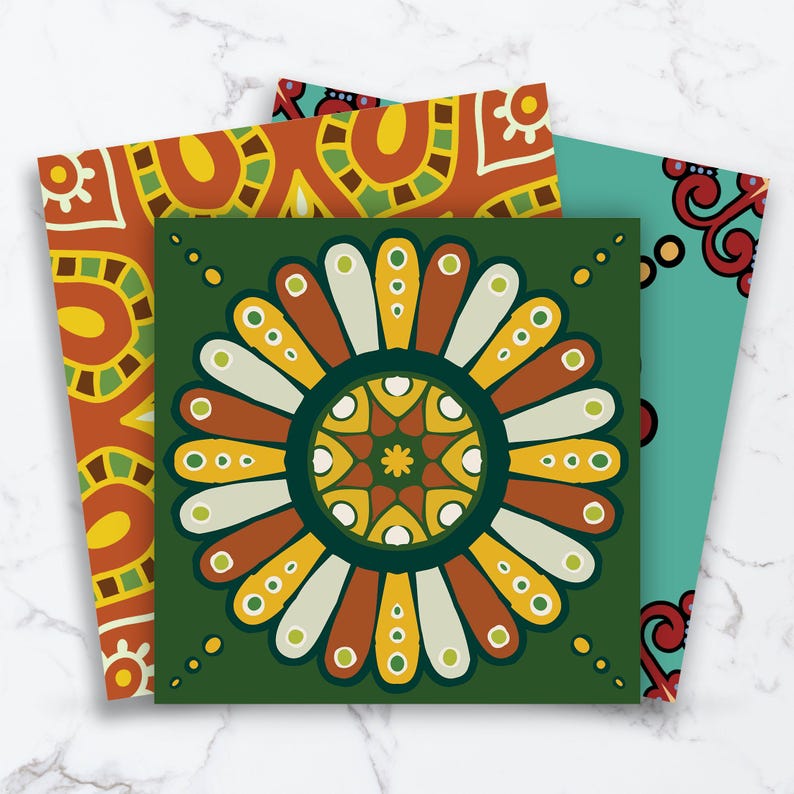 May include: Three square art prints featuring intricate patterns. The front print displays a dark green background with a large, symmetrical, multi-colored floral mandala design in shades of yellow, orange, white, and light green.