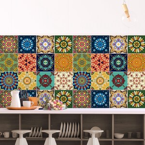 Puede incluir: Una pared cubierta con azulejos cuadrados que presentan un patr&oacute;n repetitivo de mandalas coloridos en tonos azul, verde, amarillo, rojo y naranja. Los azulejos est&aacute;n dispuestos en una cuadr&iacute;cula, creando una superficie vibrante y multicolor.