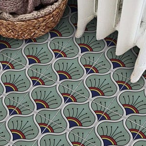Pode incluir: Azulejos decorativos com um padrão floral repetitivo. Os azulejos são de um verde suave com uma borda branca, e cada um apresenta um design floral estilizado em vermelho, amarelo e azul. Uma cesta de vime e uma cortina branca estão no fundo.