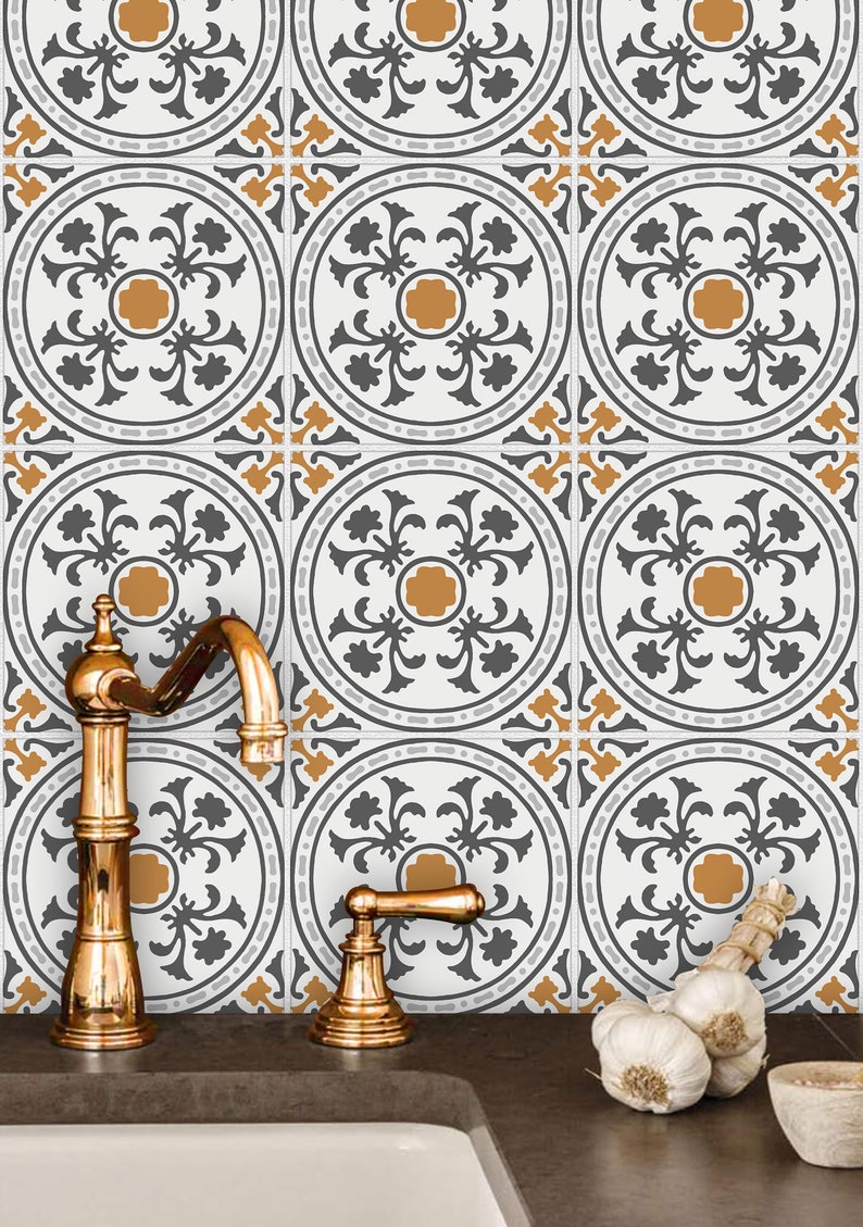 May include: A kitchen sink with gold faucets and a tiled backsplash featuring a repeating pattern of gray and orange floral designs.