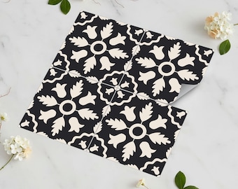 May include: Black and cream-colored decorative tile with a floral pattern. The tile design features stylized flowers and leaves arranged in a repeating geometric pattern. The tile is shown in a square arrangement.