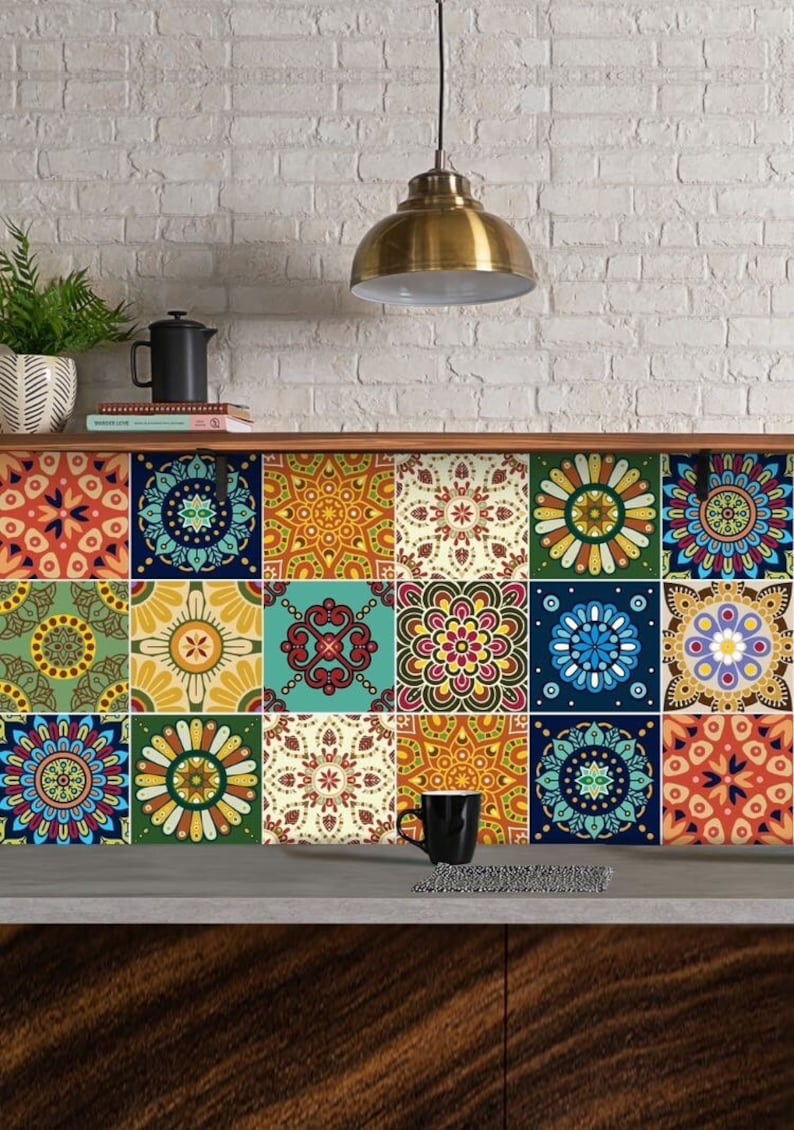 Puede incluir: Un salpicadero de pared con una cuadr&iacute;cula de dieciocho azulejos cuadrados, cada uno decorado con un patr&oacute;n geom&eacute;trico &uacute;nico inspirado en mandalas en tonos azul, naranja, amarillo, verde y rojo, dispuestos en tres filas horizontales de seis.