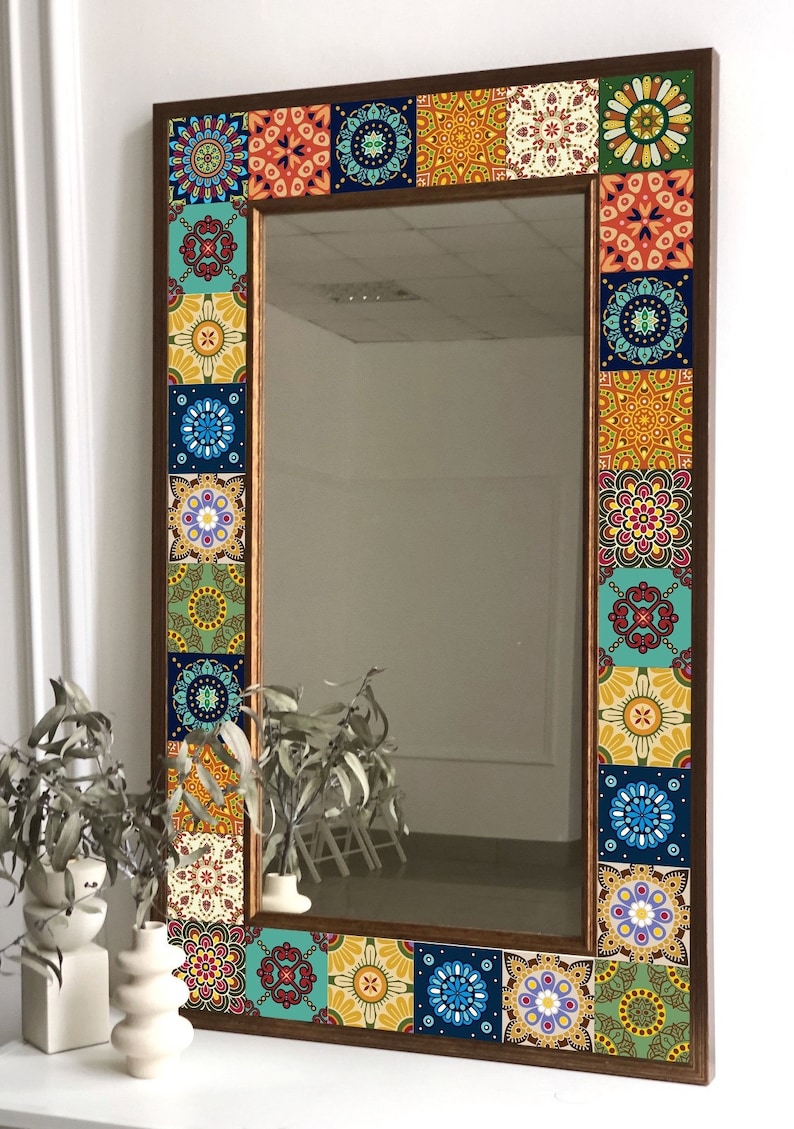 Puede incluir: Un espejo de pared rectangular con un marco de madera marr&oacute;n oscuro decorado con un borde de azulejos cuadrados coloridos. Cada azulejo muestra un patr&oacute;n intrincado inspirado en mandalas en tonos azul, amarillo, rojo, verde y blanco.