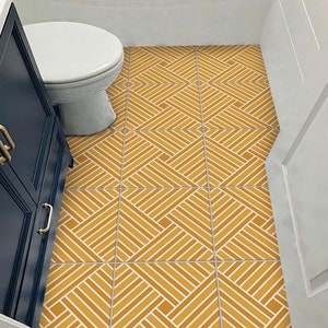 May include: A bathroom floor with yellow and white geometric patterned tiles. The tiles are arranged in a diamond pattern.