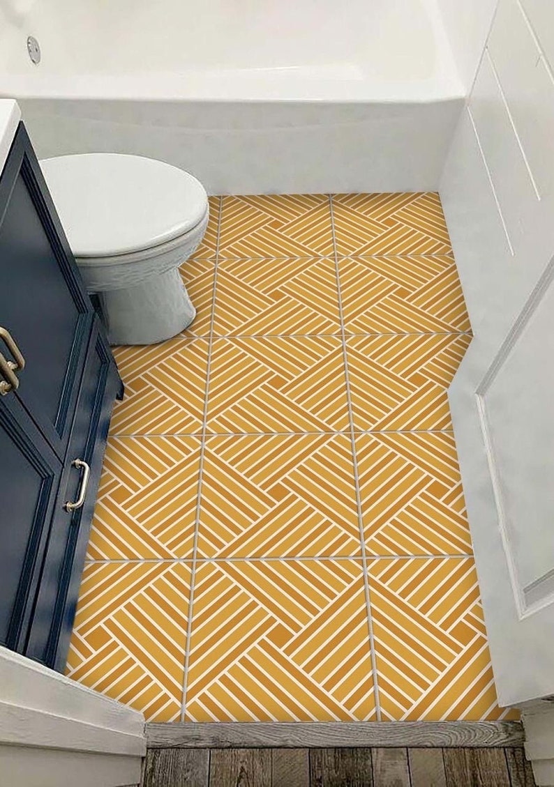 May include: A bathroom floor with yellow and white geometric patterned tiles. The tiles are arranged in a diamond pattern.