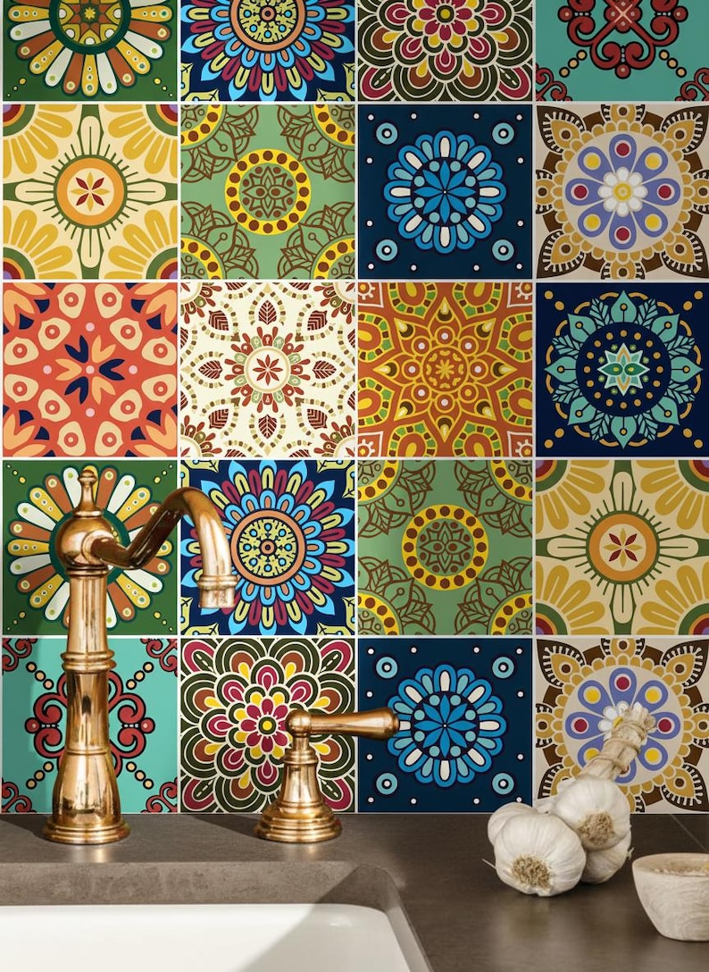 Puede incluir: Un grifo de lat&oacute;n con ca&ntilde;o curvo y una sola manija frente a una pared cubierta de azulejos cuadrados con varios patrones de mandala coloridos en tonos azul, amarillo, rojo, verde y marr&oacute;n. Un bulbo de ajo descansa sobre la encimera.