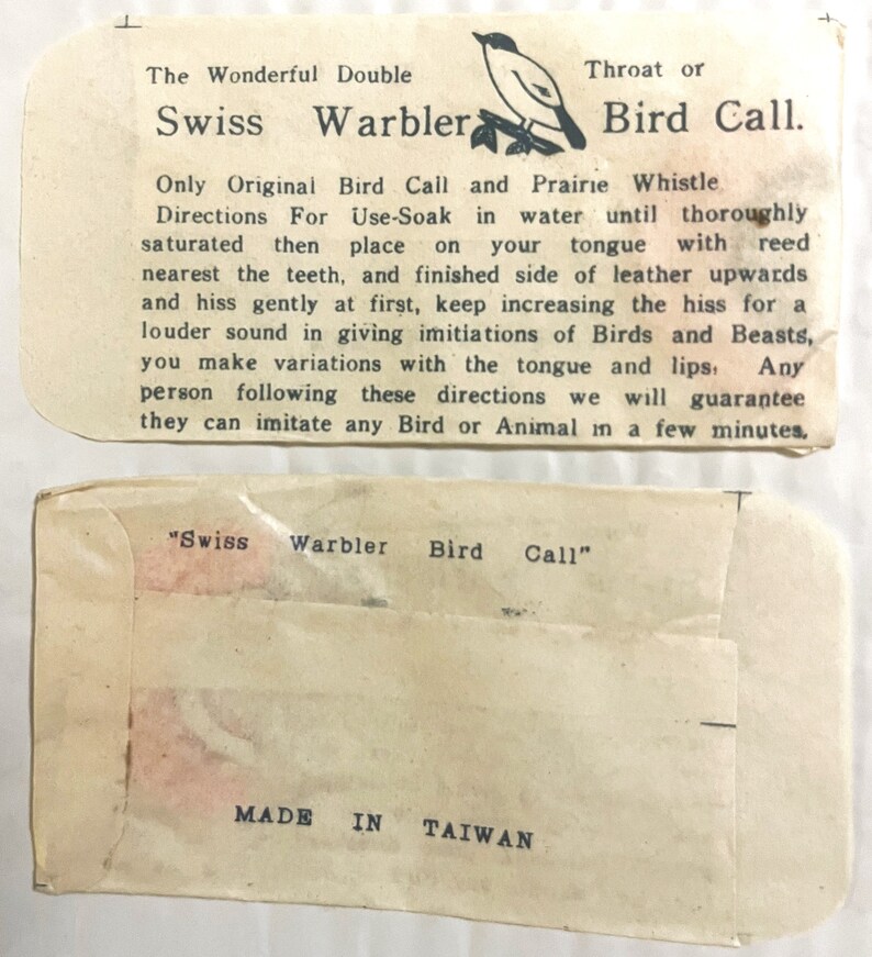 May include: A vintage card for a Swiss Warbler Bird Call. The card features a small bird illustration and text that reads "The Wonderful Double Swiss Warbler Throat or Bird Call. Only Original Bird Call and Prairie Whistle Directions For Use-Soak in water until thoroughly saturated then place on your tongue with reed nearest the teeth, and finished side of leather upwards and hiss gently at first, keep increasing the hiss for a louder sound in giving imitations of Birds and Beasts, you make variations with the tongue and lips. Any person following these directions we will guarantee they can imitate any Bird or Animal in a few minutes." The back of the card reads "Swiss Warbler Bird Call" and "MADE IN TAIWAN."
