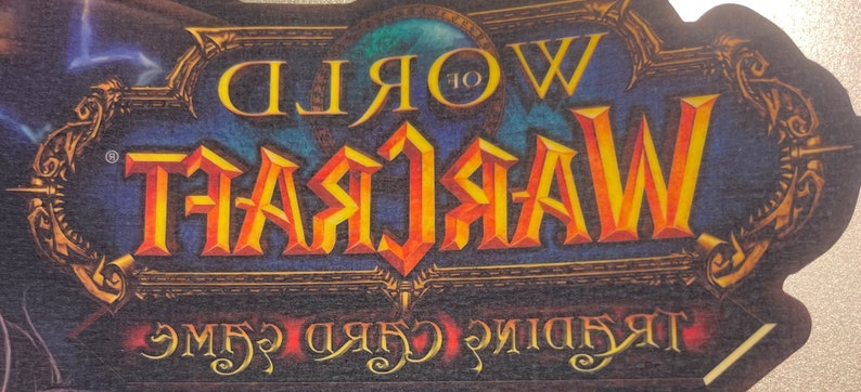 May include: A blue and gold World of Warcraft Trading Card Game logo with the text "World of Warcraft Trading Card Game" in a stylized font.