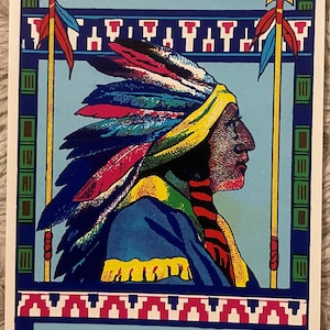 May include: A vintage illustration of a Native American man wearing a colorful headdress with feathers. He is holding a spear and standing in front of a blue background with a red, white, and blue border. The text "PRINTED IN U.S.A. 10" is printed at the bottom of the image.