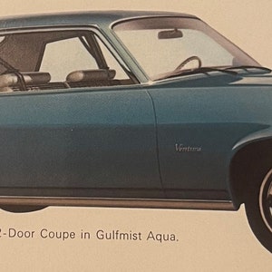 May include: A vintage Gulfmist Aqua Pontiac Ventura 2-Door Coupe. The classic car has a sleek design with chrome accents, white-walled tyres, and a Ventura emblem. The image shows the car's side profile, highlighting its curved roofline and distinctive front end.
