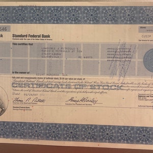 Puede incluir: Un certificado de acciones para Standard Federal Bank, un banco de ahorros federal, para ochocientas seis acciones de acciones comunes, con un valor nominal de $ 1,00 por acci&oacute;n. El certificado est&aacute; fechado el 01/28/87 y se emite a Lawrence J. Petrillo y Marie B. Petrillo, JT Ten, 23180 Laura, Southfield, MI 48075. El n&uacute;mero CUSIP es 653389 10 4.