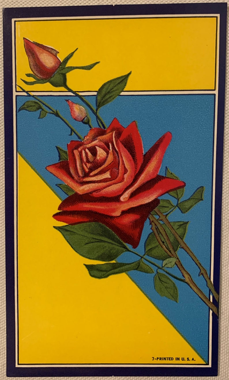 Antique broom label featuring red rose bloom and bud on yellow blue background