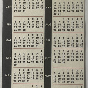Puede incluir: Un calendario vintage de Elvis Presley de 1978 con una foto en blanco y negro de Elvis en la portada. El calendario incluye una cuadr&iacute;cula mensual para cada mes del a&ntilde;o, con los d&iacute;as de la semana en negro y los n&uacute;meros en blanco. El calendario est&aacute; impreso en un fondo amarillo con acentos negros y rojos.