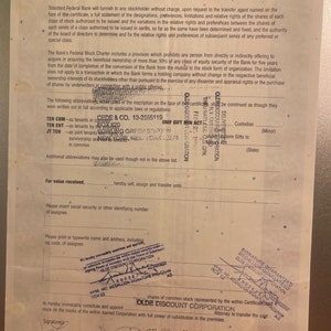 Puede incluir: Un primer plano de un certificado de acciones de Standard Federal Bank. El certificado est&aacute; fechado y firmado por dos personas. El texto en el certificado incluye los nombres "CEDE & CO." y "OLDE DISCOUNT CORPORATION".