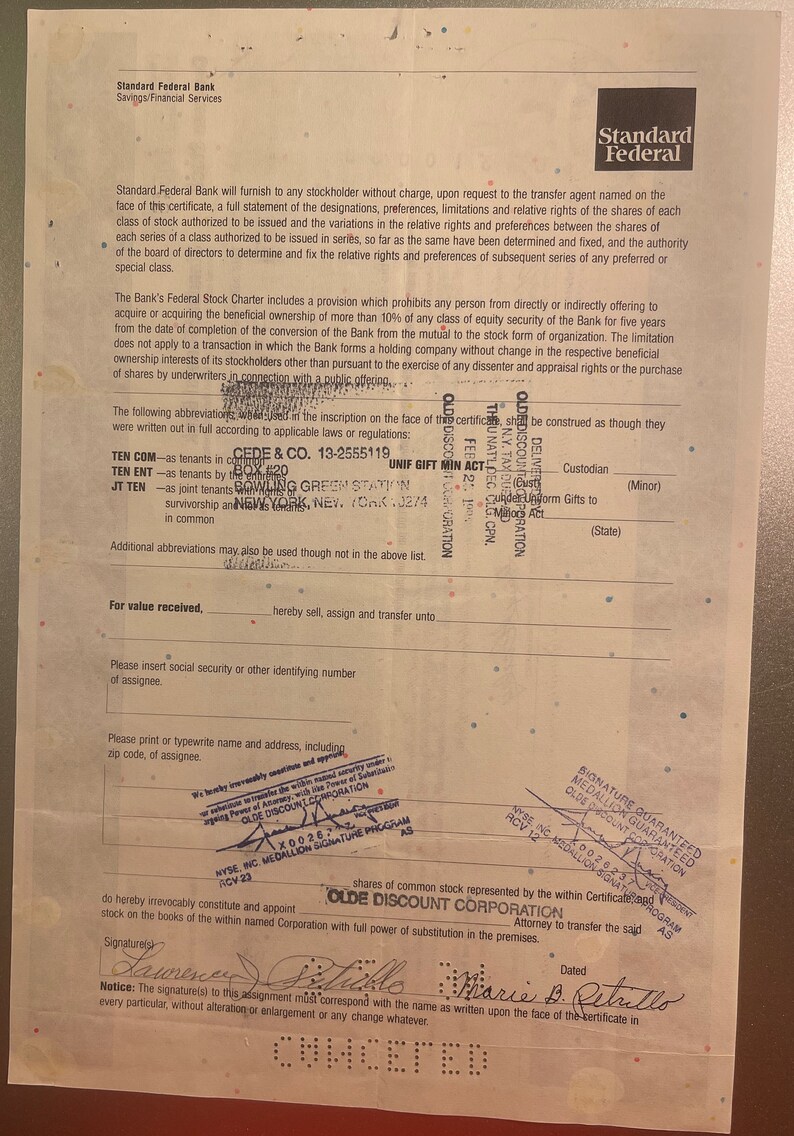 Puede incluir: Un primer plano de un certificado de acciones de Standard Federal Bank. El certificado est&aacute; fechado y firmado por dos personas. El texto en el certificado incluye los nombres "CEDE & CO." y "OLDE DISCOUNT CORPORATION".