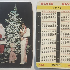Puede incluir: Un calendario de Elvis Presley de 1978 con una escena navide&ntilde;a con Elvis, Pap&aacute; Noel y un ni&ntilde;o. El calendario tiene un fondo negro con texto blanco y un borde amarillo. El texto en el calendario dice "Elvis 1978 RCA Records".