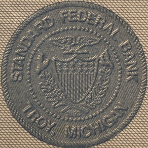 Puede incluir: Un primer plano de un sello azul y blanco con el texto "UNITED STATES FEDERAL RESERVE" y "ONE HUNDRED" alrededor del borde.