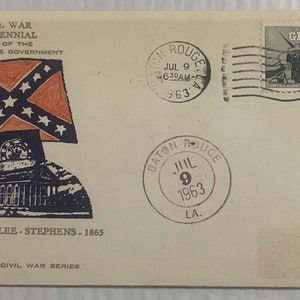May include: A vintage envelope with a Confederate flag and a stamp commemorating the Civil War Centennial. The envelope is postmarked "Baton Rouge, LA" and "July 9, 1963". The text on the envelope reads "Civil War Centennial Acts of the Confederate Government 1861-Davis-Lee-Stephens-1865 Dixipex IV Civil War Series".