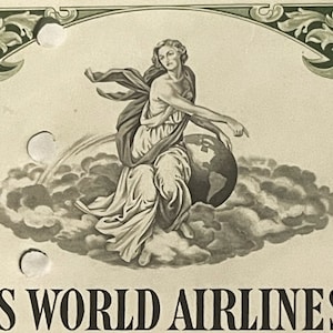 May include: A black and white illustration of a woman sitting on a globe, surrounded by clouds. The woman is wearing a flowing robe and has her arm outstretched, pointing to the right. The text "TRANS WORLD AIRLINES, INC." is printed below the illustration.