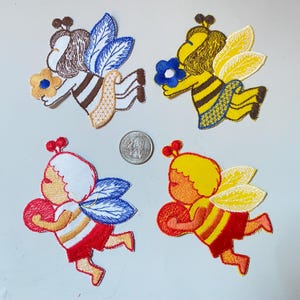 Può includere: Quattro toppe ricamate da stirare con api cartoon con ali e fiori. Le api sono marroni, gialle, rosse e arancioni con strisce nere. I fiori sono blu, gialli e rossi.