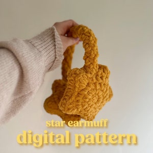May include: A crocheted star-shaped earmuff in a mustard yellow color. The earmuff is held by a hand and the text "star earmuff digital pattern" is below the earmuff.
