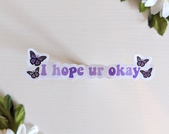 May include: A sticker with a purple ombre background and the text "I hope ur okay" in a retro font. There are three purple butterflies on the sticker.
