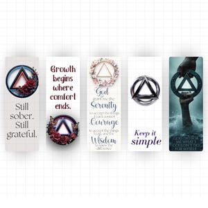Peut inclure: Cinq marque-pages rectangulaires avec des citations et des graphiques inspirants. Les marque-pages présentent un symbole triangulaire, des motifs floraux et des phrases comme "Still sober. Still grateful." et "Keep it simple."