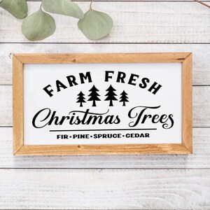 以下が含まれることがあります： 黒い文字で「Farm Fresh Christmas Trees」と書かれた木製の看板。看板には、スタイリッシュな常緑樹が4本並んだデザインと、「Fir - Pine - Spruce - Cedar」の文字も含まれています。