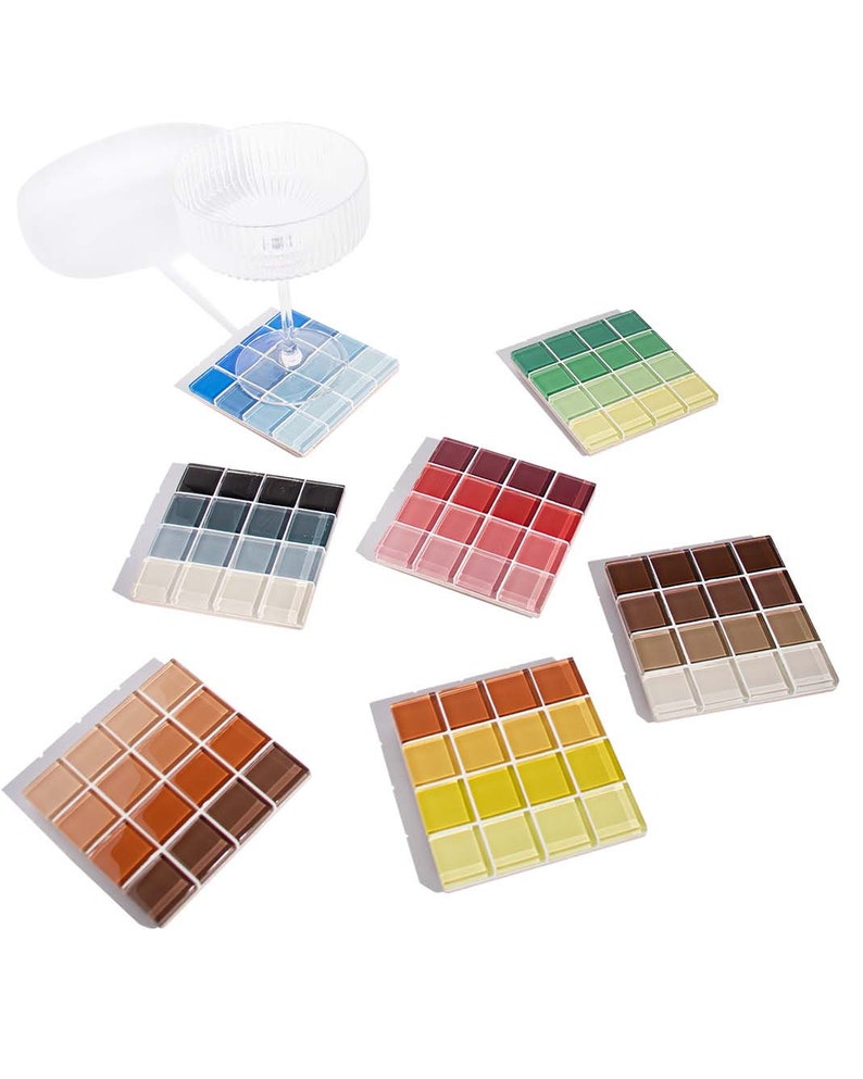 May include: Set of six square coasters made of small mosaic tiles. Each coaster features a gradient of colors, including blue, green, red, brown, orange, and yellow.