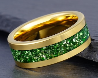 Könnte beinhalten: Ein goldener Ring mit einem grünen Glitzerband. Das Band besteht aus kleinen, grünen, glitzernden Stücken.