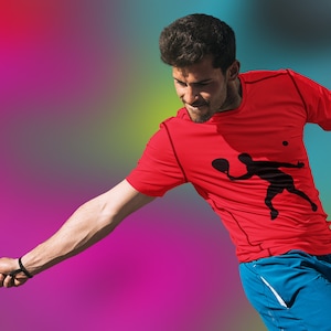 May include: A man wearing a red t-shirt with a black silhouette of a person playing paddle tennis. He is holding a paddle tennis racket and is in mid-swing.