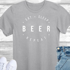 May include: A gray t-shirt with the text "Eat. Sleep. Beer. Repeat." printed in white.
