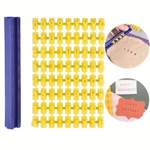 May include: A set of yellow plastic alphabet stamps with a blue handle. The stamps are arranged in rows and columns, and they include all the letters of the alphabet. The stamps can be used to create custom messages on a variety of surfaces, such as clay, fondant, or soap.