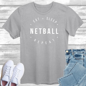 May include: Grey t-shirt with the text "Eat. Sleep. Netball. Repeat." printed in white.