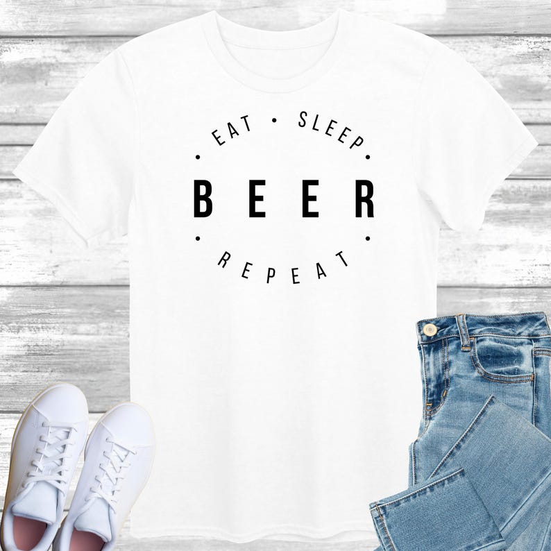 May include: White t-shirt with black text that reads "Eat. Sleep. Beer. Repeat."