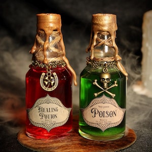 Peut inclure: Deux flacons de potion décoratifs, un rouge et un vert, avec des détails dorés. La bouteille rouge est étiquetée "Healing Potion" et possède un charme en forme de fer à cheval. La bouteille verte est étiquetée "Poison" avec un charme de crâne.