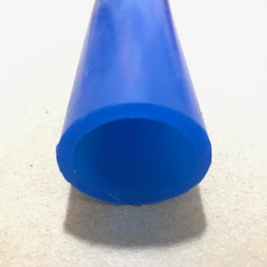 Puede incluir: Primer plano de un tubo de silicona azul. El tubo es flexible y tiene una superficie lisa.