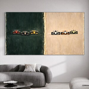 Puede incluir: Pintura abstracta con coches de carreras de Fórmula 1. La obra de arte está dividida en dos secciones: un lado verde oscuro y un lado beige. Los coches están representados en varios colores, incluyendo rojo, negro y amarillo. La pintura se exhibe sobre un sofá gris.