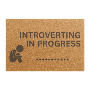 May include: A brown doormat with the text "Introverting in progress" and a small silhouette of a person sitting with their head down.