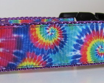 May include: A purple and black dog collar with a tie-dye pattern in shades of blue, red, yellow, and green.