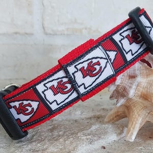 May include: Red, white and black dog collar with a repeating pattern of the Kansas City Chiefs logo. The collar has a black buckle.