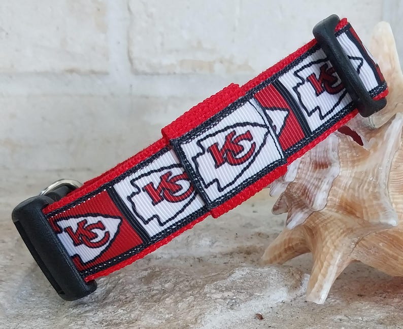 May include: Red, white and black dog collar with a repeating pattern of the Kansas City Chiefs logo. The collar has a black buckle.