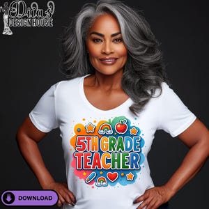 Puede incluir: Una camiseta blanca con un gráfico colorido que dice "5th Grade Teacher". El diseño incluye un arcoíris, estrellas, una manzana y otros elementos decorativos. La camiseta tiene cuello redondo.