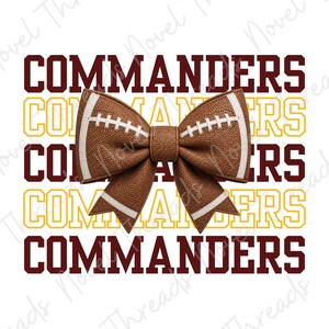 May include: A brown textured faux leather hair bow shaped like a football with white laces and stripes, centred over a repeating background pattern of the word COMMANDERS in dark red and yellow block lettering on a white background.