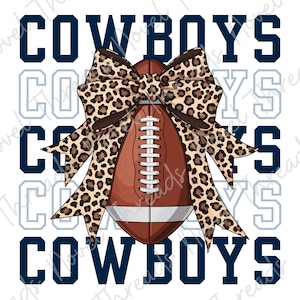 May include: A brown American football with white laces and stripes, adorned with a large leopard print bow. The word COWBOYS is printed in bold navy blue block letters in the background, repeated in a lighter outline font behind the main text.