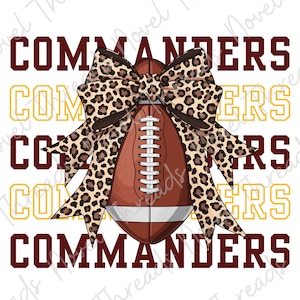 May include: A brown football with white laces and a white stripe is centered behind a large leopard print bow. The word COMMANDERS is repeated in a stacked pattern in the background, alternating between dark maroon and yellow block lettering.